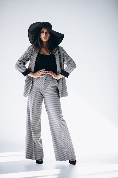 Free photo young woman in a business suit wearing a hat