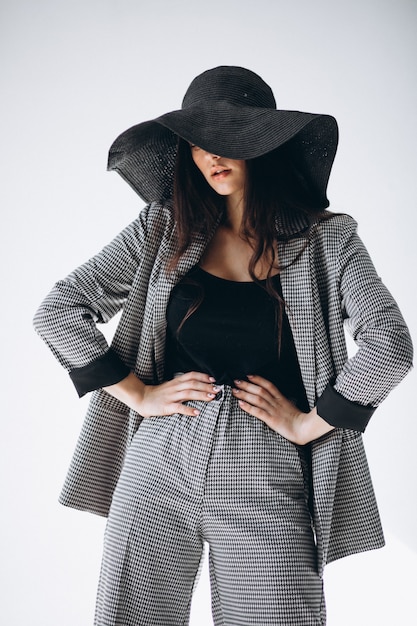 Free photo young woman in a business suit wearing a hat