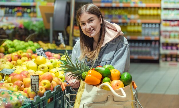 A young woman buys groceries in a supermarket.