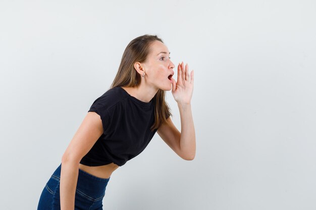 Young woman calling someone in black blouse and looking impatient.