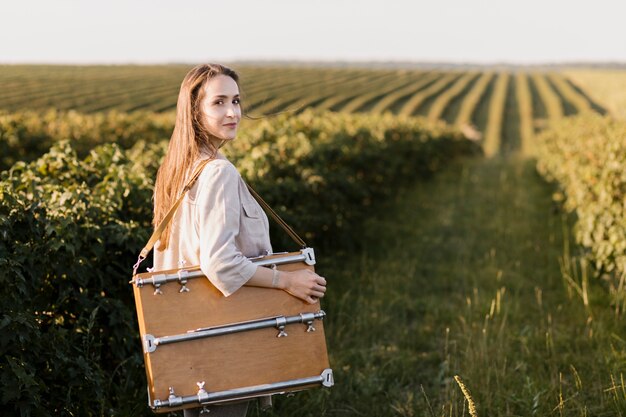 Young woman carrying painting box