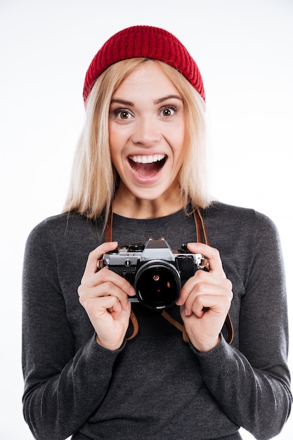 Giovane donna in abbigliamento casual che sta e che tiene retro macchina fotografica