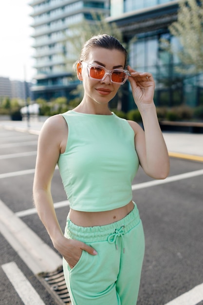 young woman in casual suit using wireless headphones outdoor