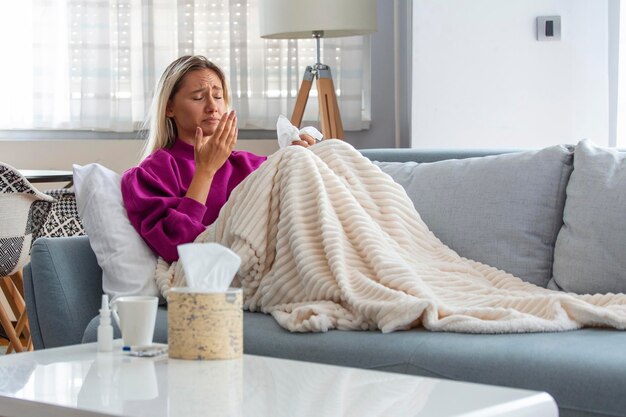 young woman caught cold or flu illness portrait of unhealthy girl blowing her nose