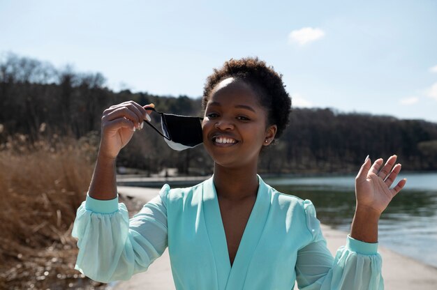 Young woman celebrating the lifting of face mask restrictions outdoors in the city