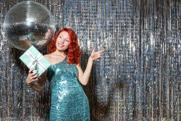 young woman celebrating new year holding present in party