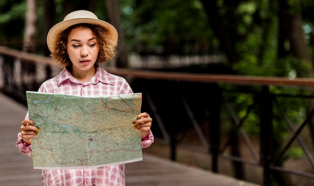 コピースペースを持つ新しい目的地の地図をチェックする若い女性