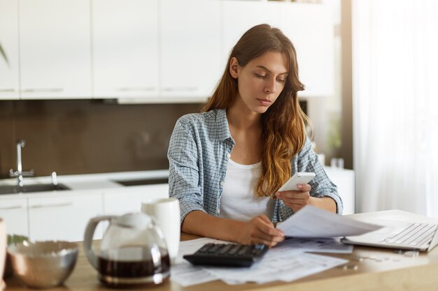Young woman checking her budget and doing taxes