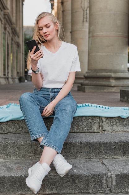 Free photo young woman checking her phone