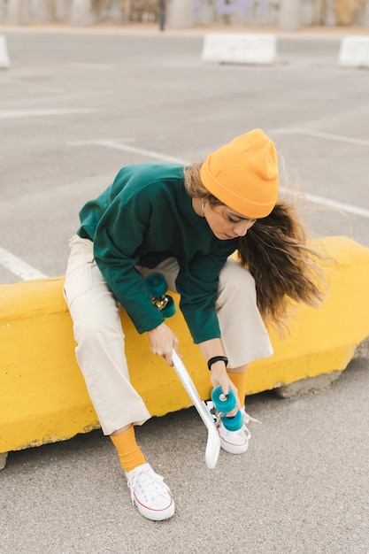 Young woman checking skateboard