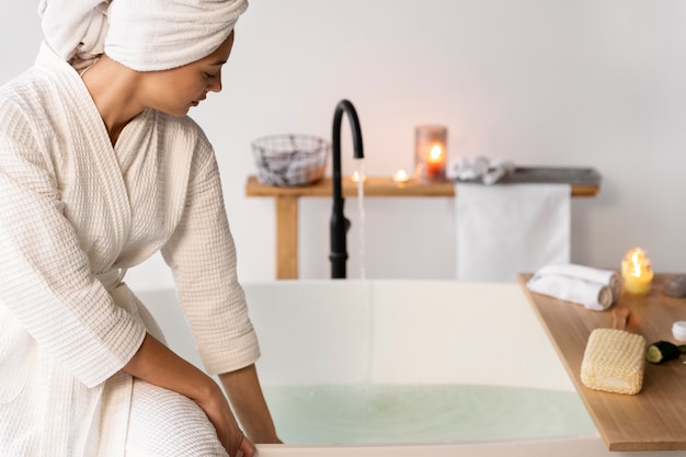 Young woman checking the water before taking a bath