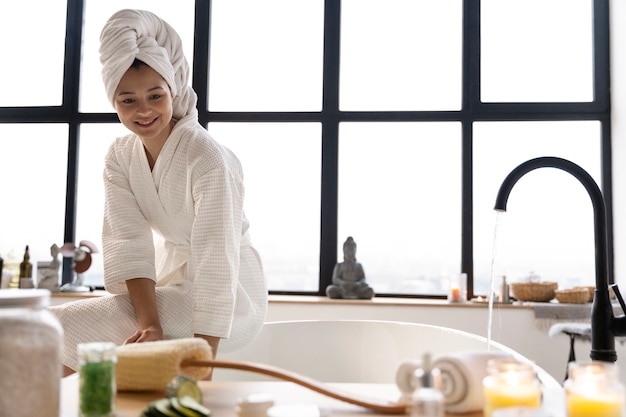 Giovane donna che controlla l'acqua prima di fare il bagno