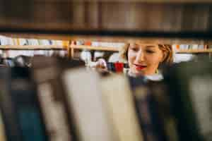 Free photo young woman choosing book at the library