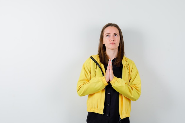 Young woman clasping hands in praying position