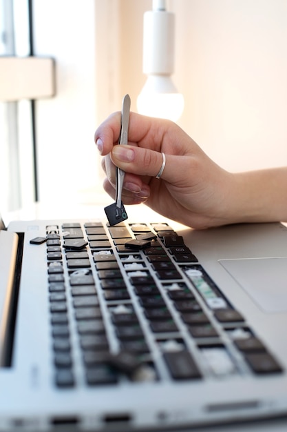 Young woman cleaning her laptop key board