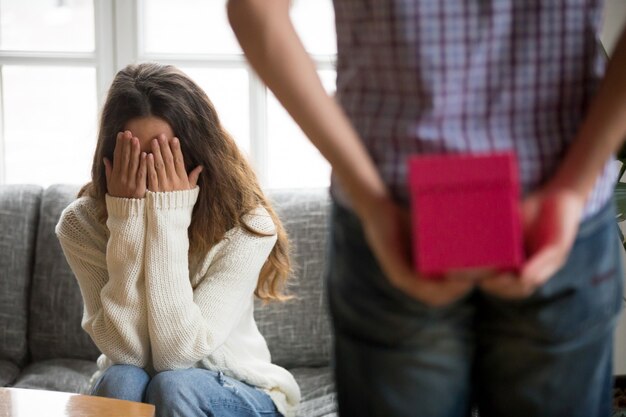 Young woman closing eyes with hands waiting for present surprise