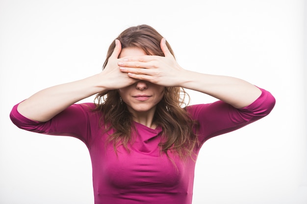 Free photo young woman closing her eyes with two hands against white background