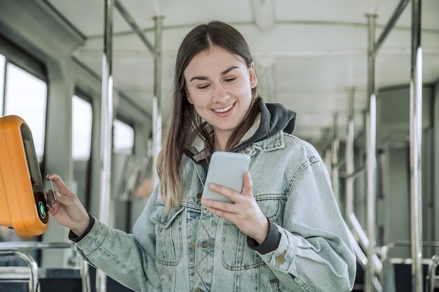 A young woman contactless pays for public transport.