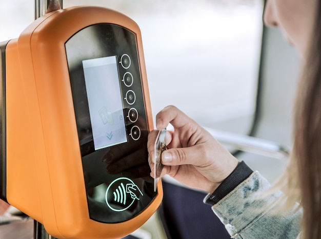 A young woman contactless pays for public transport