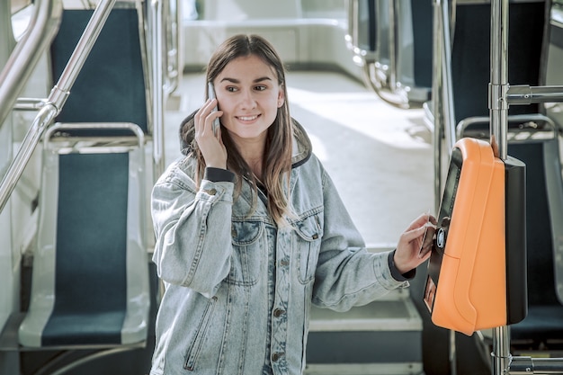 Free photo a young woman contactless pays for public transport