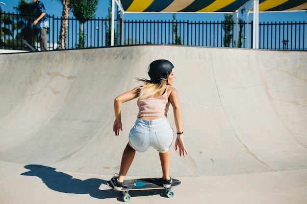 Free photo young woman at cool pose during skating