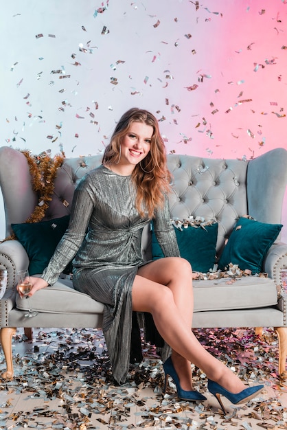 Free photo young woman on couch with champagne glass