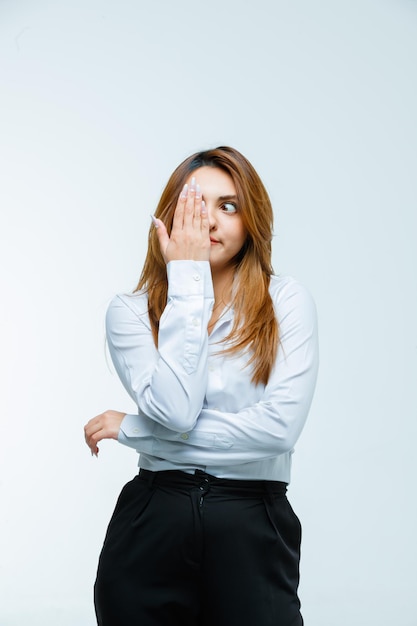 Free photo young woman covering eye with hand and looking cute