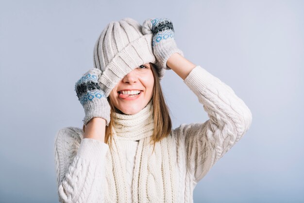 Young woman covering face with light cap