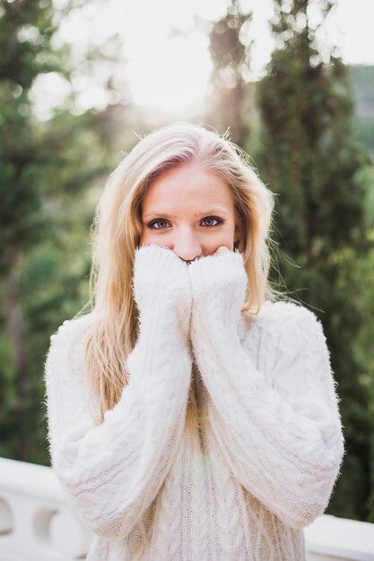 Young woman covering half face with hands