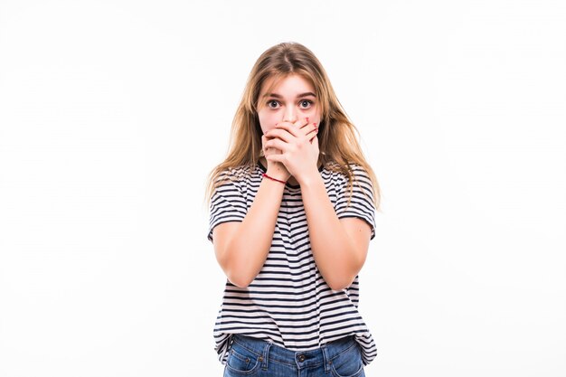 Young woman covering her mouth, isolated on white wall