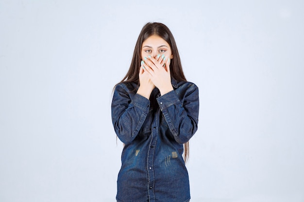Free photo young woman covering her mouth and keeps silence
