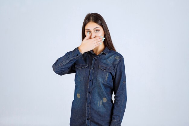 Young woman covering her mouth and keeps silence