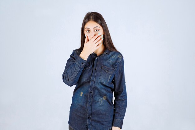 Young woman covering her mouth and keeps silence