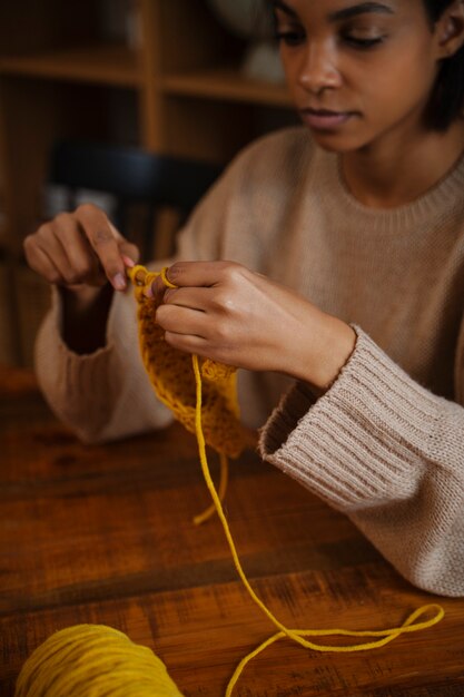 Young woman crocheting at home