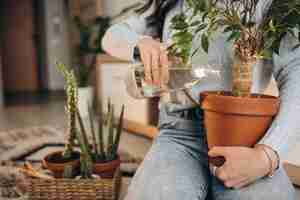 Free photo young woman cultivating plants at home