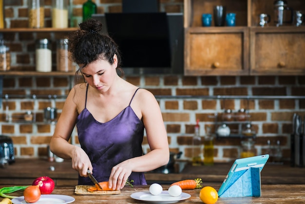 Young woman cutting carrot