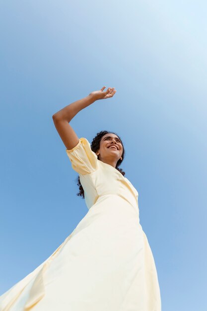 Young woman dancing on sky background