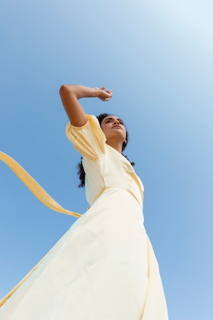 Foto gratuita giovane donna che balla sul fondo del cielo