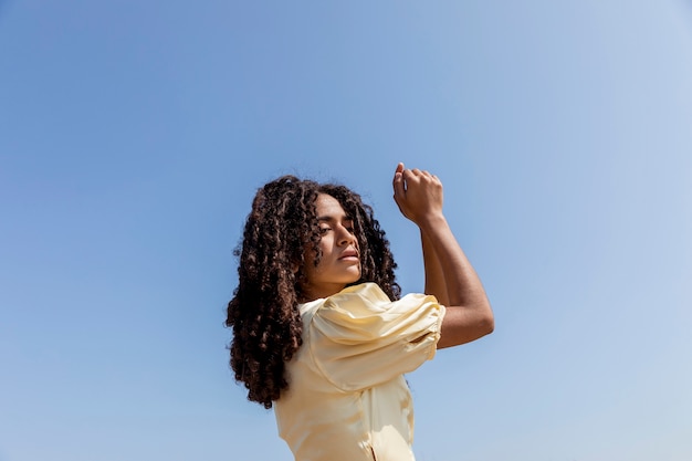 Free photo young woman dancing on sky background