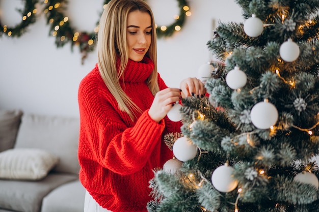 クリスマスツリーを飾る若い女性