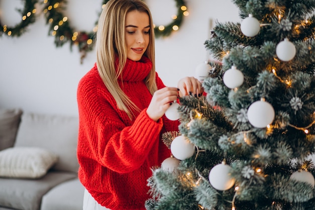 Young woman decorating christmas tree