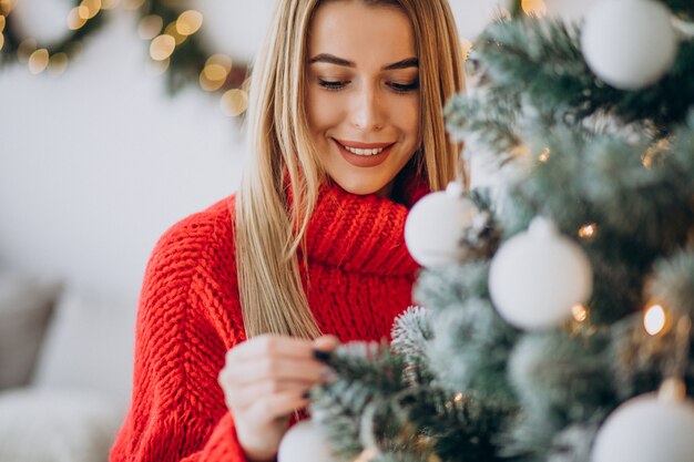 クリスマスツリーを飾る若い女性