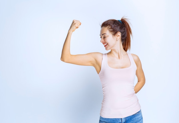 Young woman demonstrating her arm muscles, profile view