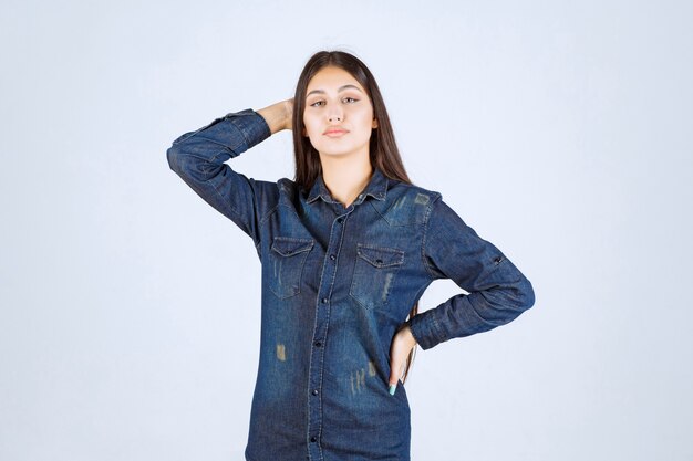 Young woman in denim shirt giving neutral poses without reactions