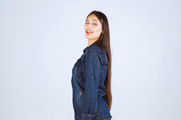 Young woman in denim shirt giving neutral poses without reactions