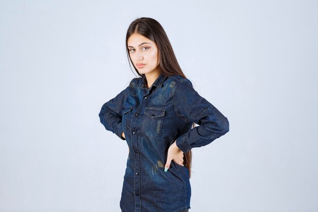 Молодая женщина в джинсовой рубашке принимает нейтральные и соблазнительные позы без реакции