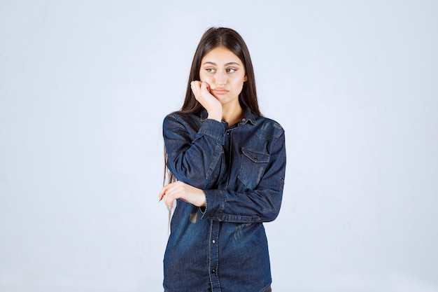 Young woman in denim shirt looks surprized and excited