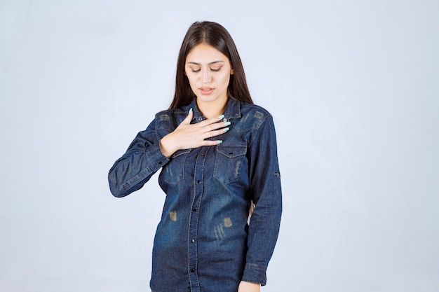 Young woman in denim shirt smiling and making pretty face