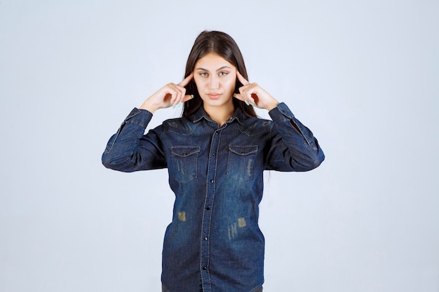 Young woman in denim shirt thinking and planning