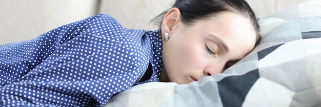 Young woman in depression lies on couch with mobile phone waiting for a call or sms from guy